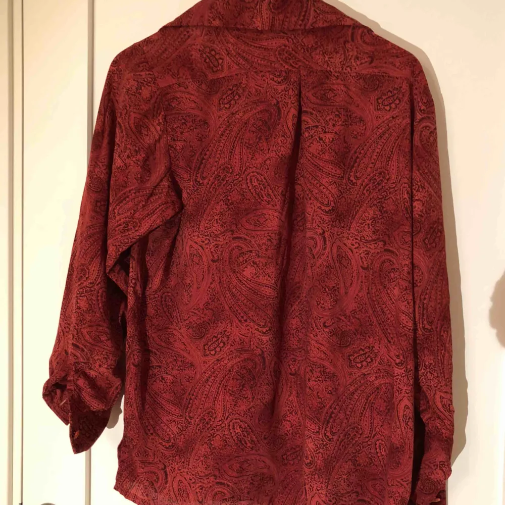 En röd skjorta i mjukt luftigt material, perfekt till sommaren och en lite oversize fit. Inga lösa trådar eller knappar som saknas. (Inte inklusive frakt, det står köparen för!). Skjortor.