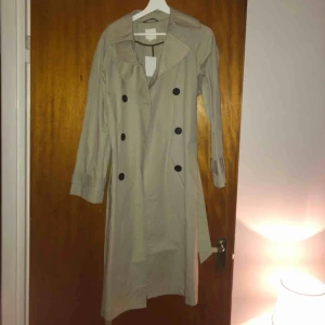  - Säljer denna fina trenchcoat från H&M. ALDRIG ANVÄND. Lappen sitter kvar. inköpt för 600kr, storlek XS. 