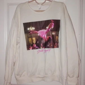  - Säljer denna snygga tjocktröja från hm i storlek L! Krämvit tjocktröja med tryck på som är en scen från "dirty dancing". Väldigt snygg men kommer tyvärr inte till användning. Tröjan är knappt använd så den är som ny! 