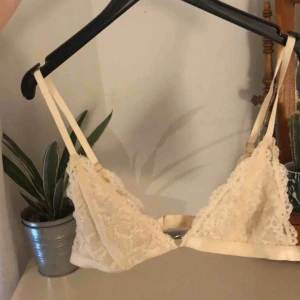  - Skön krämfärgad bralette i spets. Fint skick. Passar någon med lite större byst. Köparen står för frakt:)