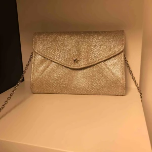  - Glittrig partyväska från next, knappt använd. Kan användas både som clutch och crossbodyväska.