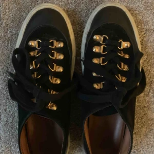  - Sneakers i svart mocka med gulddetaljer från svenska Rodebjer. Mycket fint skick! 