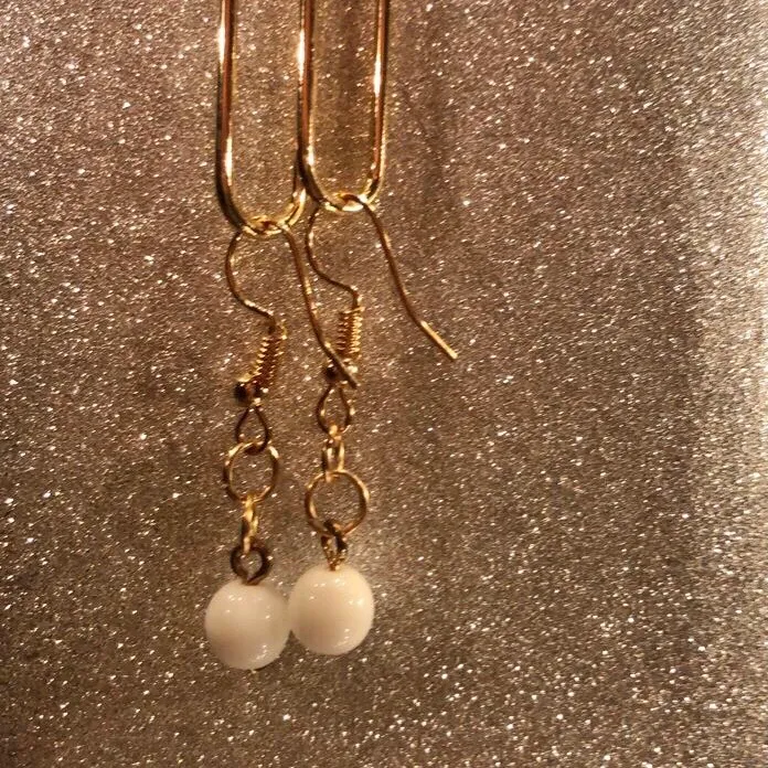 Vita små handgjorda pärlörhängen med guldfärgade hängen . Accessoarer.
