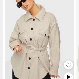 Nelly my dearest shacket i beige ! Strl 34  - Strl 34! Den är i bra skick! Säljs då jag aldrig använder den och tycker inte det var helt min stil . Hittade ingen bild från hemsidan på exakt den jag har men det är samma som på första bilden fast bältet är annourlunda .   Budgivning om fler är intresserad och vill köpa
