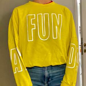 A yello sweatshirt with the word fun in the middle 