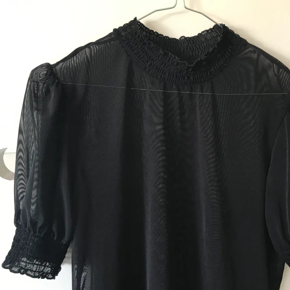 En svart mesh-tröja med puffärmar, passar vilken storlek som helst! . Toppar.