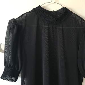 En svart mesh-tröja med puffärmar, passar vilken storlek som helst! 