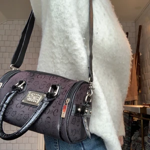 Guess väska - As snygg och ball vintage guess väska! Lite y2k vibe. Har massor av smarta fack på sidorna och även inuti! Snygga läder detaljer och diamanter på loggan! Köpt secondhand för flera år sedan och är väldigt unik! Lägg ett bud i kommentarerna från 150kr (buda minst med 15kr) köpare står för frakt! 💓💓 KÖP DIREKT FÖR 300kr