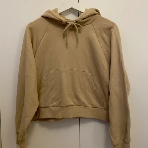Hoodie - En mysig beige hoodie från Monki. Färgen ser lite ljusare ut i verkligheten. Använd en gång. Storleken är L men det är en kort modell. Priset är 30kr + frakt