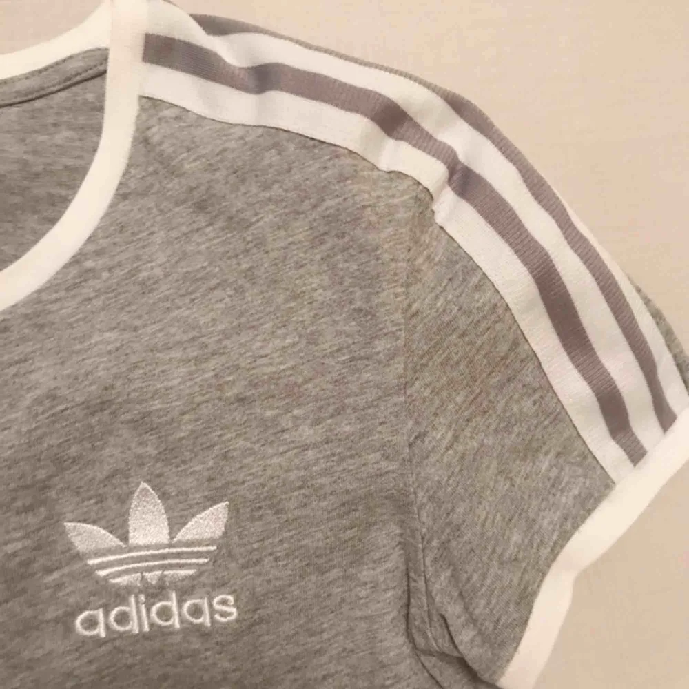 Snygg ljusgrå t-shirt från Adidas 🔥🔥Den har lite tunnare halskrage än den på första bilden, vilket man kan se på den andra bilden:) . T-shirts.