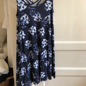 Blommig Klänning - en väldigt skön klänning. perfekt för att dra på sig något snabbt. Passar inte längre min stil eller passform så därför säljer jag den. 