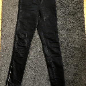 Byxor - Ormskinnsimitation. Dragkedja i sidan. Är ungefär storlek XS-S