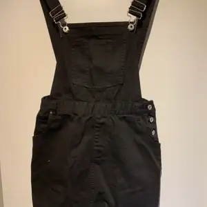 En svart jeans klänning med hängslen. Aldrig använt prislappen kvar. Dock lite liten i storleken