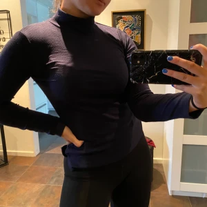 Mörkblå polotröja - Mörkblå ribbad polotröja. Säljer pga att den inte används längre. Lätt att matcha till allt. 