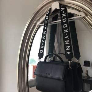 Crossbody bag från nakd - Svart, rymlig, crossbody bag, i läder imitation. Medföljer två olika axelband, ett i skinn och ett med loggan. Använd en gång, väldigt bra skick. Nypris 500