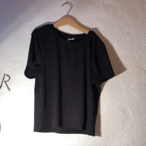 Svart ribbad t-shirt - Svart ribbad t-shirt, croppad. Från Gina tricot. Storlek L. Finns en exakt likadan i vit, köper du den och den vita blir det 25kr. Annars 20kr/tröja