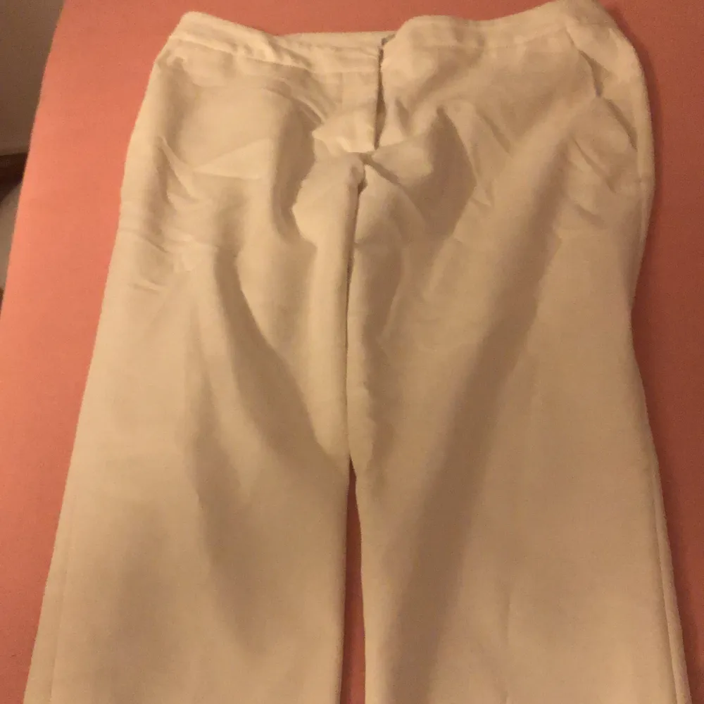 Vita kostymbyxor med backfickor från h&m i storleken 36. Jeans & Byxor.