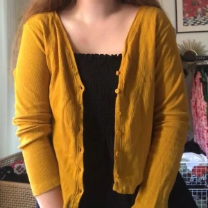 Gul kofta - Säljer denna fina ribbiade gula koftan med knappar köpt från asos, den är i jättefint skick då den aldrig är använd ❤