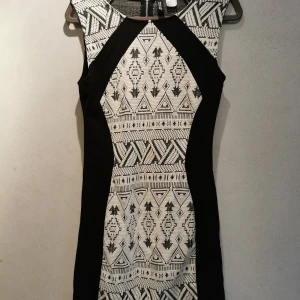 Kort, mönstrad klänning - Kort, mönstrad och figurnära klänning. Kortärmad, stretching med en kort dragkedja i nacken. Använd några gånger. 