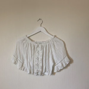 Vit off shoulder top - Jättegullig off shoulder top med fina detaljer och resår nedtill. Storlek S. Aldrig använd. Priset går att diskuteras.Köparen står för frakten! 