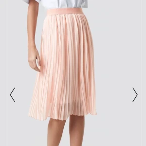 Rosa kjol från NAKD  - En plisserad rosa kjol från nakd i storlek M. Använd ca 2-3 gånger så i väldigt fint skick. Första bilden är tagen från deras hemsida men dem andra två är tagna av mig. Kjolen är köpt för 400kr. Säljer för 200 + frakt. Tar swish!