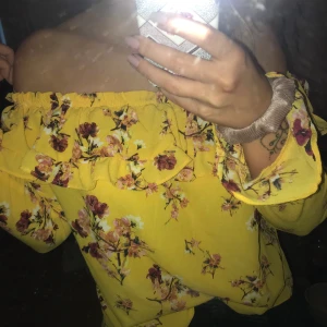 Blommig och gul topp från H&M - Säljer denna knappt använda topp från hm då detta inte riktigt var min stil på kläder. Tröjan är i storlek 42 men är mycket liten i storlek. Kan mötas upp, vid frakt står köparen för kostnaden