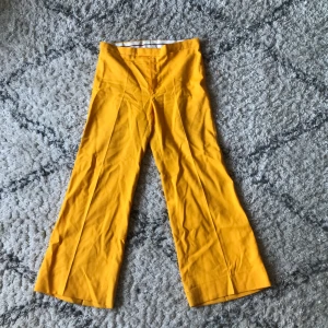 Gula 70-tals byxor i storlek m - Ett par söta vintage byxor i storlek m/38 med små tusch fläckar längst ned se bild 2 och 3. Köparen står för frakt annars möts jag i Liljeholmen och slussen ✨