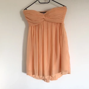 Axelbandlös klänning - Köpt på Nelly, har använts vid ett tillfälle. Storlek 36.