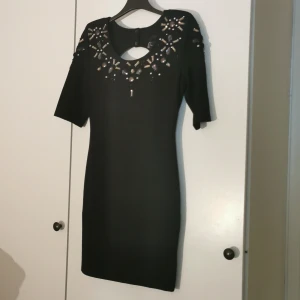 Snygg bodyconklänning. Stl 34 - Snygg bodyconklänning med snygg urringning och öppen rygg. Små axelvaddar för snygg passform. Aldrig använd. Prislapp kvar. Köpare står för frakt. 