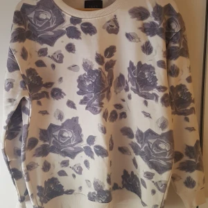 tröja från saints & mortals strl M - mysig tjocktröja med lila blommor strl M, perfekt för kyliga sommarkvällar. lite noppig, men annars bra kvalitet. 180kr + frakt. 