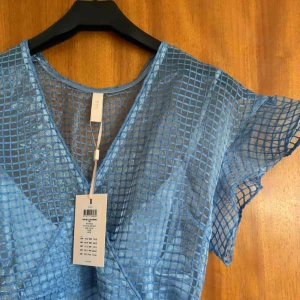  - Superfin klänning! Svår att få med på bild så hör av dig för bättre bilder! Knytband i midjan och jättefina armar samt volang längst ner. Helt ny och oanvänd. Pris kan alltid diskuteras. Hör av dig för fler bilder eller frågor 🥰