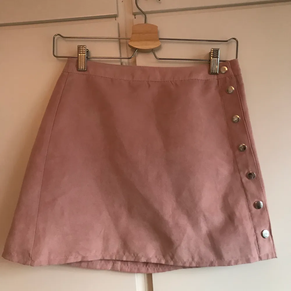 En rosa minikjol i mockaimitation från H&M. Köparen står för frakt. Kjolar.