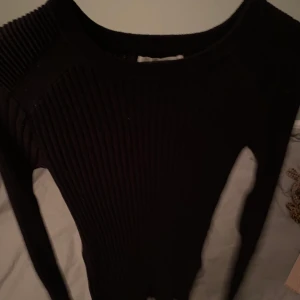 Svart långärmad  - Svart stickad långärmad som ändå är rätt tunn. skön på höst/vår o vinter. Har ribbat mönster på axlarna. Sitter bra på mig som är S/M