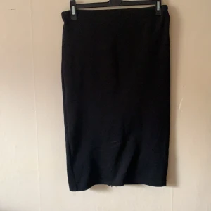 Kjol - Kjol från HM som är knälång med en dragkedja nedtill baktill.