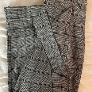 grårutaiga vida byxor från nakd - gråa vida byxor med rutigt mönster, band till att knyta i midjan och dragkedja i sidan