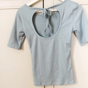 Härlig blå tröja - Lite längre t-shirt!  I en fin blå färg men lite öppen rygg & knytsnören. 