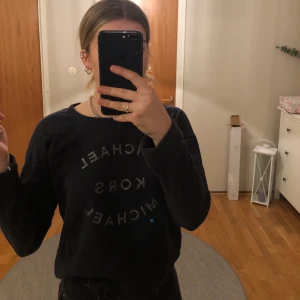 Michael Kors tröja  - Skit snygg mörkblå tröja från Michael Kors med en sluten detalj på texten. En snygg knytningsdetalj nertill. Bra skick. Frakt ingår i priset.
