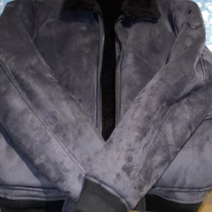 Armani bomberjacka äkta ull/mocka - En elegant och varm bomberjacka från armani, passar till alla tillfällen. Med äkta ull som fodring så håller man sig varm även under kalla dagar, yttermaterial utav mocka som en extra touch som lyfter ens outfit. Använd en gång! Fler bilder kan skickas självklart är den helt äkta..