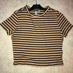 Randig t-shirt - Superfin randig tshirt som jag bara använt några gånger. Verkligen superfin och skön material. färgerna är brun, svart och vit som e skitfint