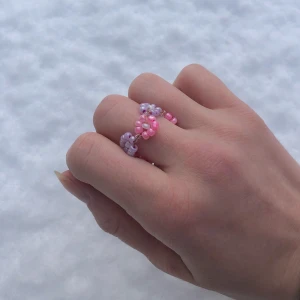 Blomster ring! - Fin pärlring med rosa och lila blommor runtom, handgjord, går att få i flera olika färger/storlekar. Skriv privat så kan jag anpassa ringarna:) Tar swish, pris kan diskuteras.