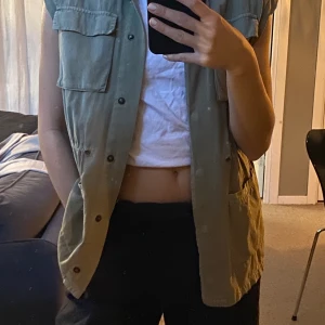 Avklippt väst - En grön avklippt väst som från början var en tunnare jacka. Cool till bara en t-shorts eller som den är. Använt 1 gång. 