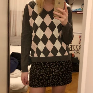 Rutig långärmad tröja - Grå v-ringad tröja med rutor i vitt och ljusrosa. Passar bra på mig som har storlek s, den sitter lite oversized. Använd men i fint skick. Kan mötas i Stockholm annars betalar köpare frakt <3