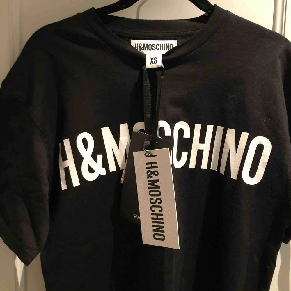 Helt oanvänd T-shirt från MOSCHINOs samarbete med H&M. Ett av de plagg som sålde slut direkt! Storlek XS fast herrmodell så snarare en S i dam. . T-shirts.