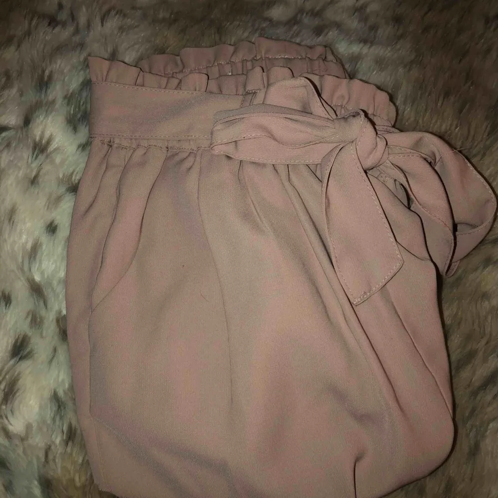 Ett par kostymbyxor från Bikbok i en ljus rosa färg. Dem är hela över allt och har använt dem typ 3 kvällar. Säljer dem på grund av att det inte riktigt är min stil längre. Frakten ligger på runt 50kr. Jeans & Byxor.
