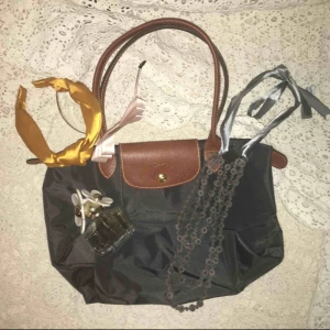  - En mini Longchamp väska använd bara ett fåtal gånger. Super fint skick, som ny. Grå färg och i en mindre storlek. Köpt i Longchamp affären i London.