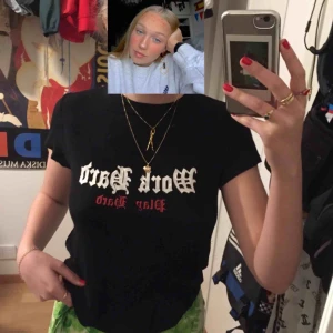  - Svart t-shirt. Står ”Work Hard, Play Hard” på framsidan.