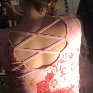  - Cool 90-talströja med blommor på. Detaljer på ryggen. Materialet är tunt och stretchigt.