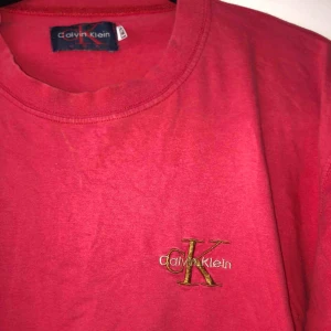  - Röd Calvin Klein t-shirt i strl L men passar mindre storlekar! 