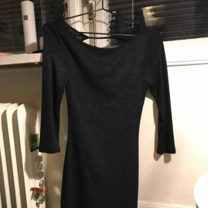  - Glittrig fin oanvänd (lappen är kvar) klänning med öppen rygg från Mango