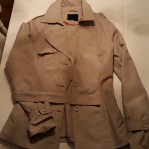  - Ej använd beige trenchcoat, perfekt till våren eller sommaren! Hämtas i Mehedeby eller kan tas till Tierp!